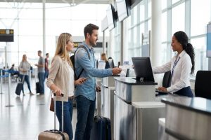 Man and woman waiting at the airport terminal preparing for international travel.