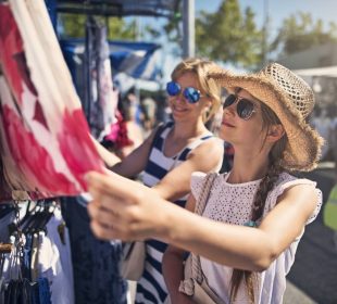 A lady picking a dress from a local store, illustrating how to experience a city like a local