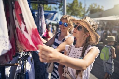 A lady picking a dress from a local store, illustrating how to experience a city like a local