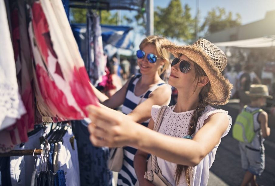 A lady picking a dress from a local store, illustrating how to experience a city like a local