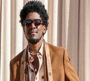 Labrinth in an event wearing a brown jacket