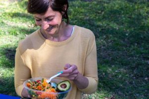 A lady eating in Mindful Portions and Sustainable Choices