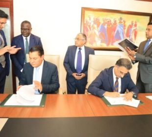 Tanzanian billionaire Rostam Aziz, signing documents