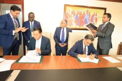 Tanzanian billionaire Rostam Aziz, signing documents