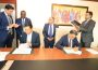 Tanzanian billionaire Rostam Aziz, signing documents