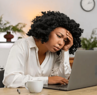 a lady staring at her laptop tired