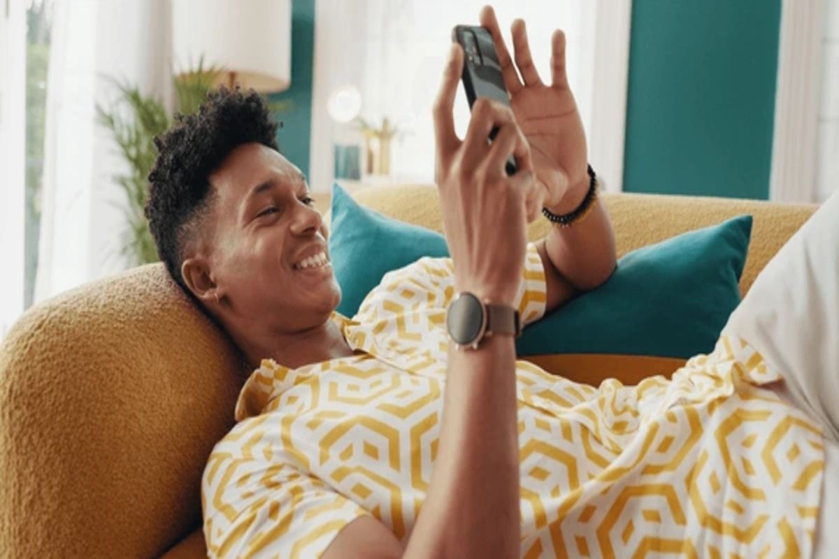 A guy pressing his phone while smiling