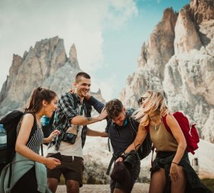 Two men playing beside two women, sharing laughs and moments inspired by budget friendly travel tips.