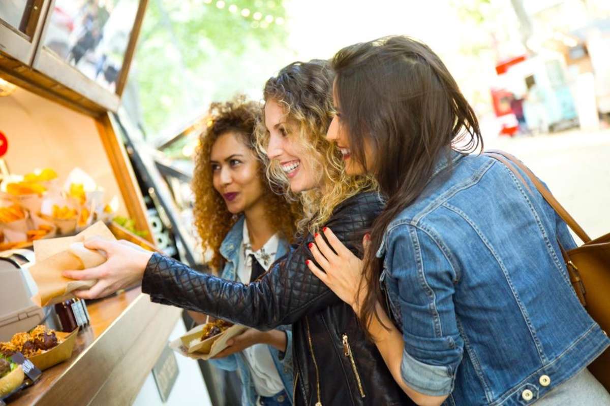 Three ladies buying food from a local spot