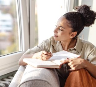 A lady journaling indoors, illustrating how journaling can improve your life.