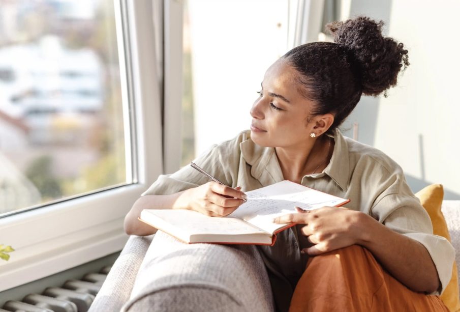 A lady journaling indoors, illustrating how journaling can improve your life.
