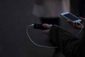 A person holding a phone and an Travel Gadgets, a powerbank
