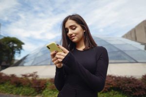 A lady researching her international travel destination on a phone while planning her trip.