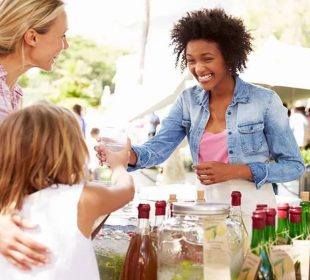 A woman and her child having a converation with a stall owner, illustrating How to Experience a City Like a Local