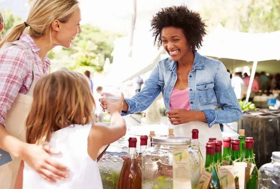 A woman and her child having a converation with a stall owner, illustrating How to Experience a City Like a Local