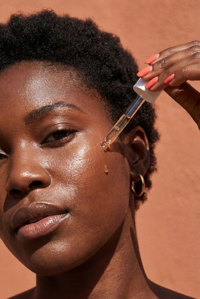 woman applying serum on face