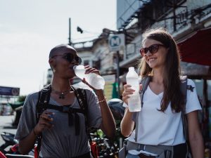 Two ladies walking with water in their hands