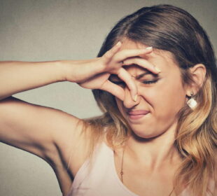 A woman covering her nose with her hands
