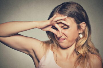 A woman covering her nose with her hands